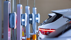 In der Tiefgarage ist ein Auto gerade mit der Ladesäule verbunden und wird geladen.